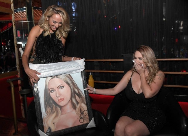   Alycia Browne presents Melissa Meeks with a painting by Meeks at her official divorce party at the Crazy Horse 3 Gentlemen's Club on June 30, 2018 in Las Vegas, Nevada. 