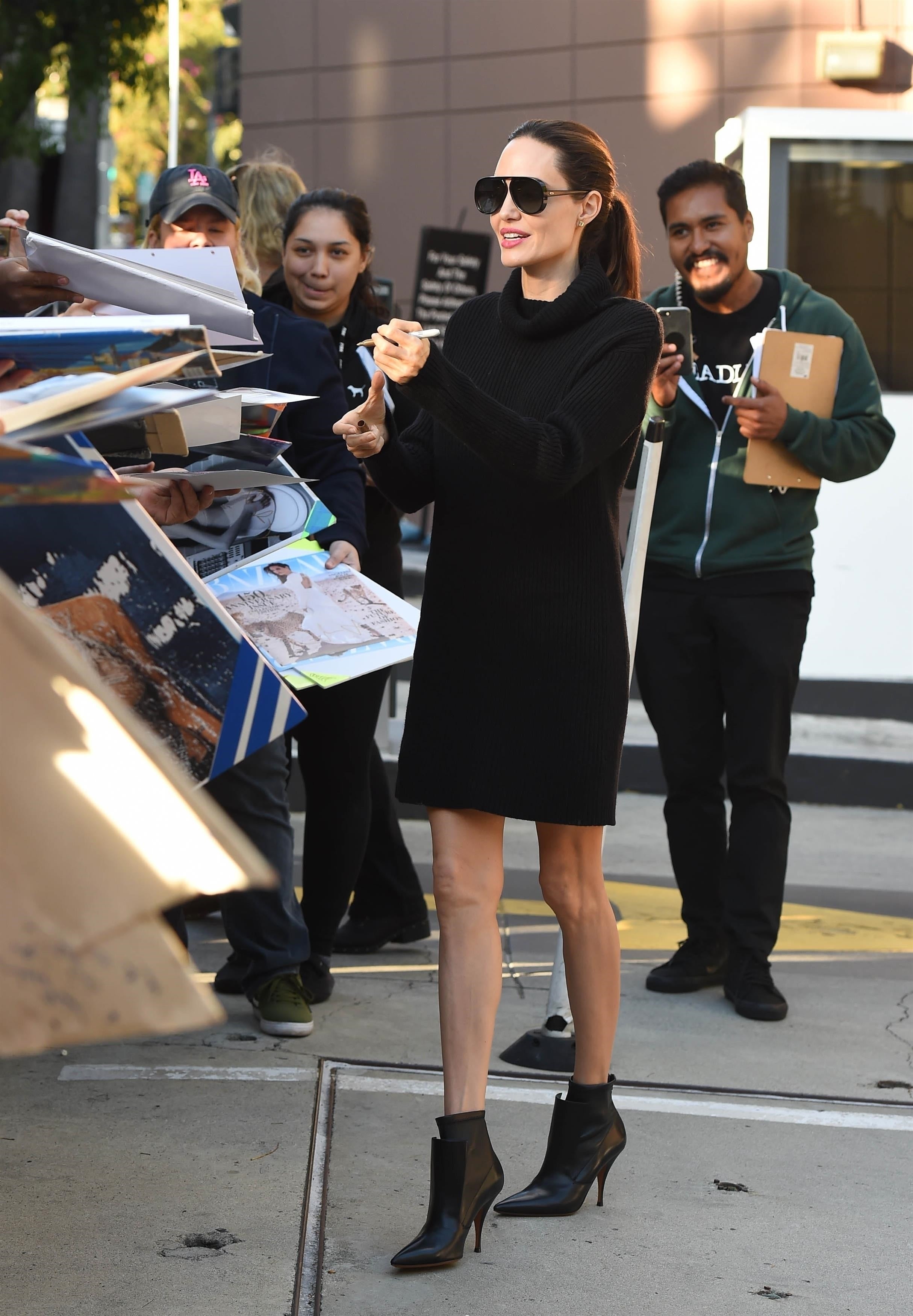 Angelina Jolie in black blazer with black tall boots, black