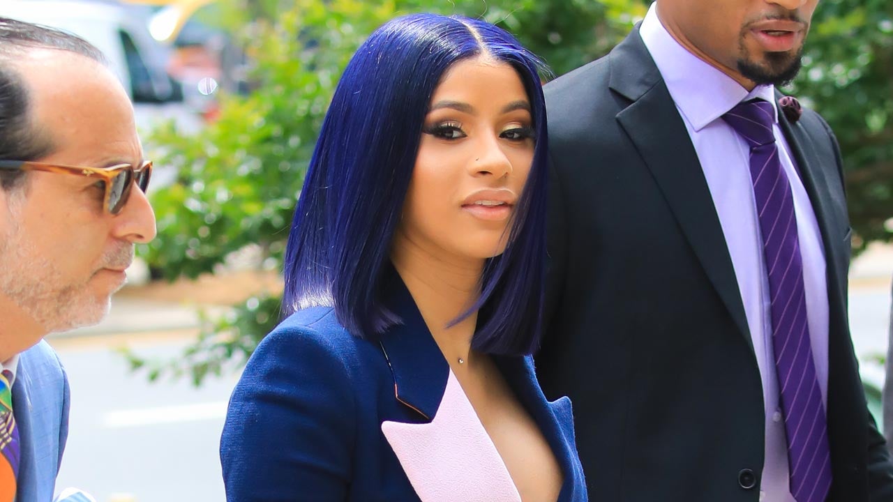 Cardi B dons a baby blue suit with a red shirt and pumps as she