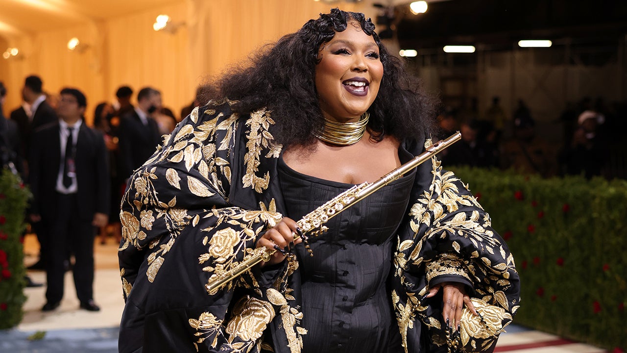 Lizzo stuns a ruby red body suit and a pair of well-worn Doc