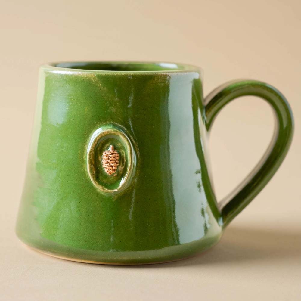 https://www.etonline.com/sites/default/files/images/2023-11/Black%20Oak%20Artisan%20Pinecone%20Green%20Mug.jpg