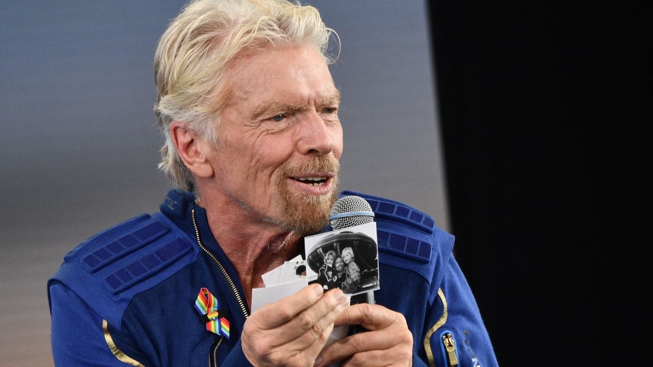 Sir Richard Branson holds up photos that he brought with him into space, as he speaks after flying into space aboard a Virgin Galactic vessel, a voyage he described as the "experience of a lifetime" -- and one he hopes will usher in an era of lucrative space tourism at Spaceport America, near Truth and Consequences, New Mexico on July 11, 2021