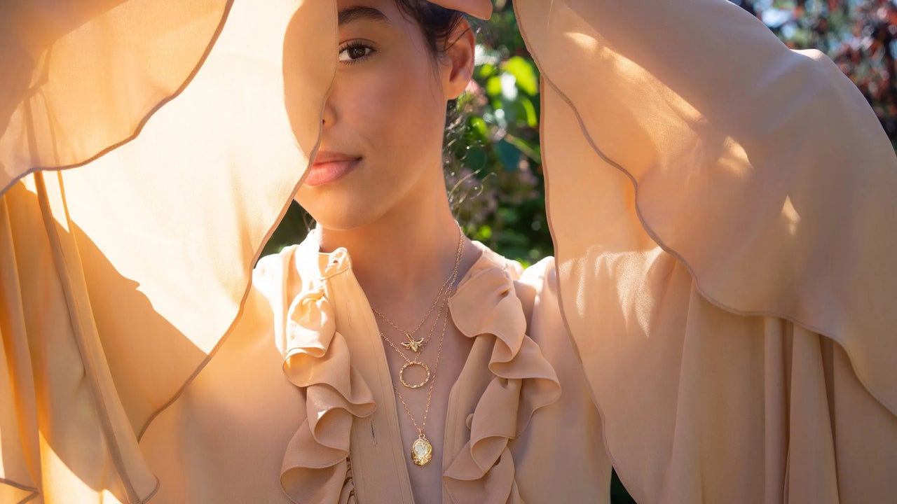 Woman in flowy top wearing Bridgerton Jewelry