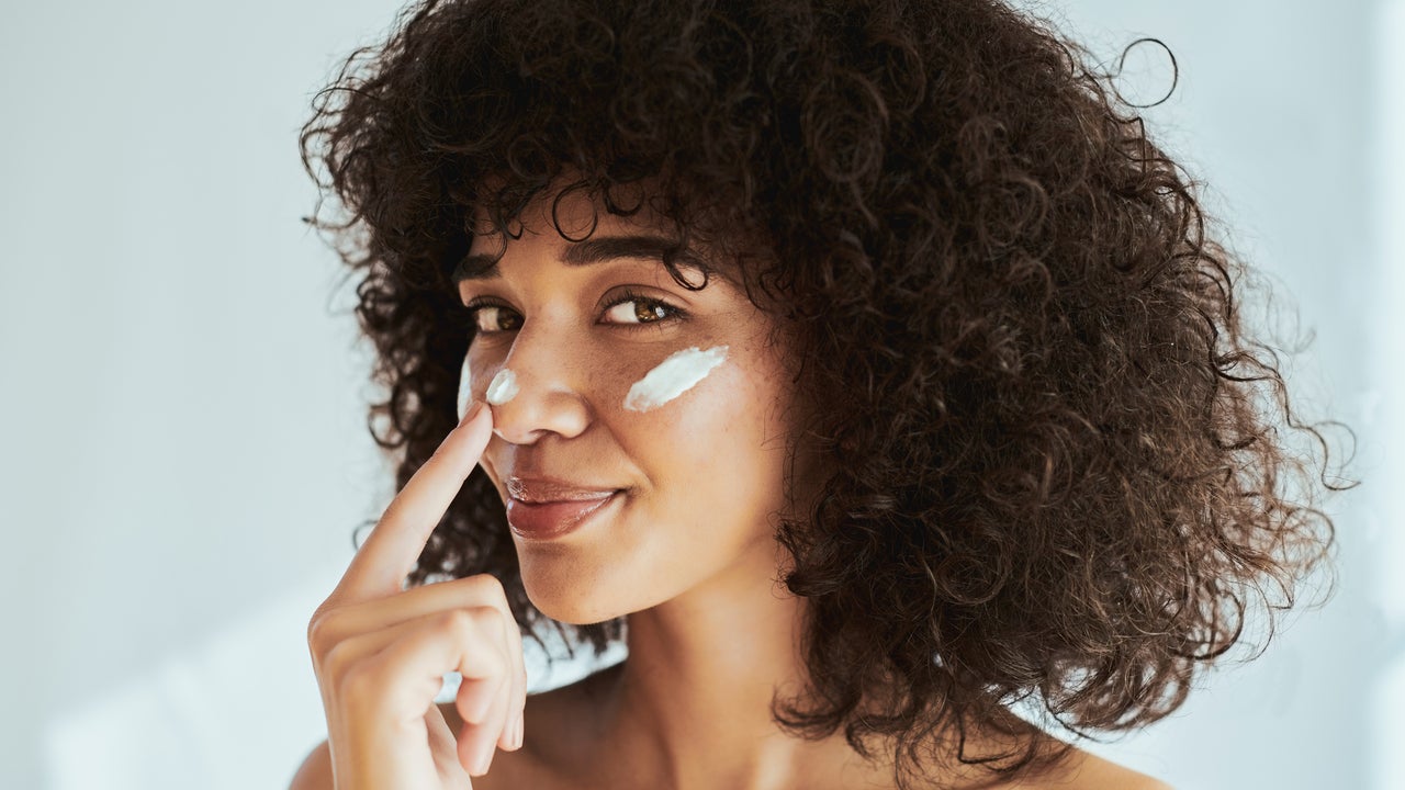 Woman applying sunscreen to face