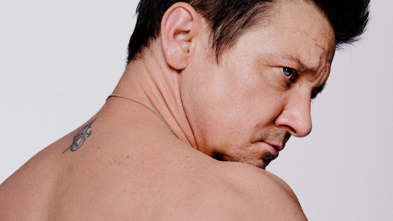 Jeremy Renner appears shirtless on the cover of the magazine and shows scars from a snow plow accident
