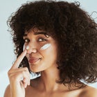 Woman applying sunscreen to face