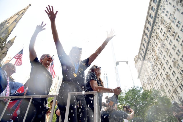 Megan Rapinoe, Allie Long and Alex Morgan celebrate while riding on a float 