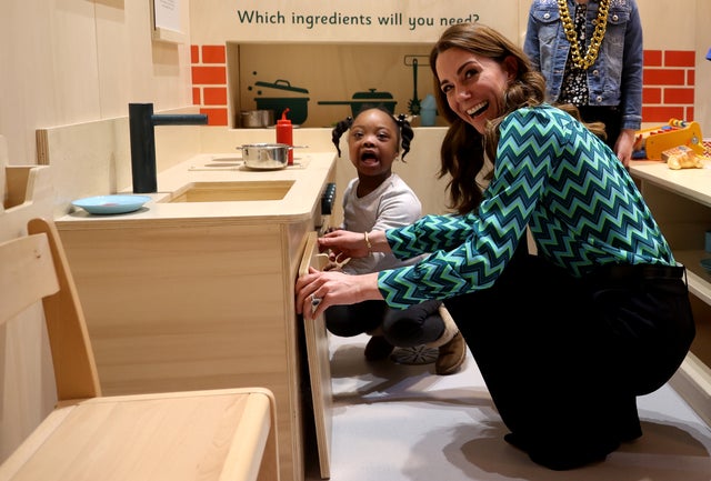 Catherine, Duchess of Cambridge plays with a child as she visits MiniBrum