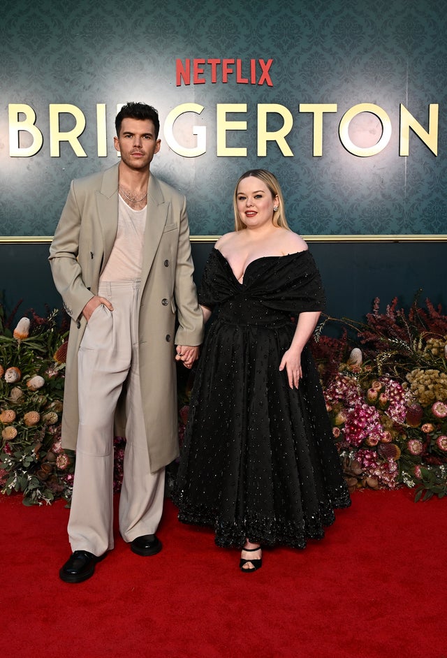 Luke Newton and Nicola Coughlan hold hands during Bridgerton event in Australia.