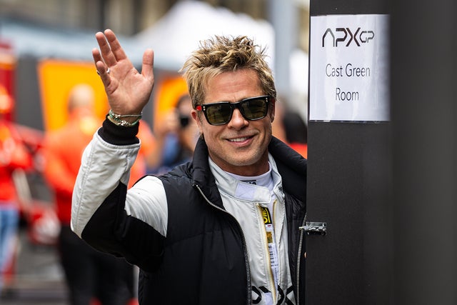 Brad Pitt waves to onlookers on the set of his upcoming Formula One movie.